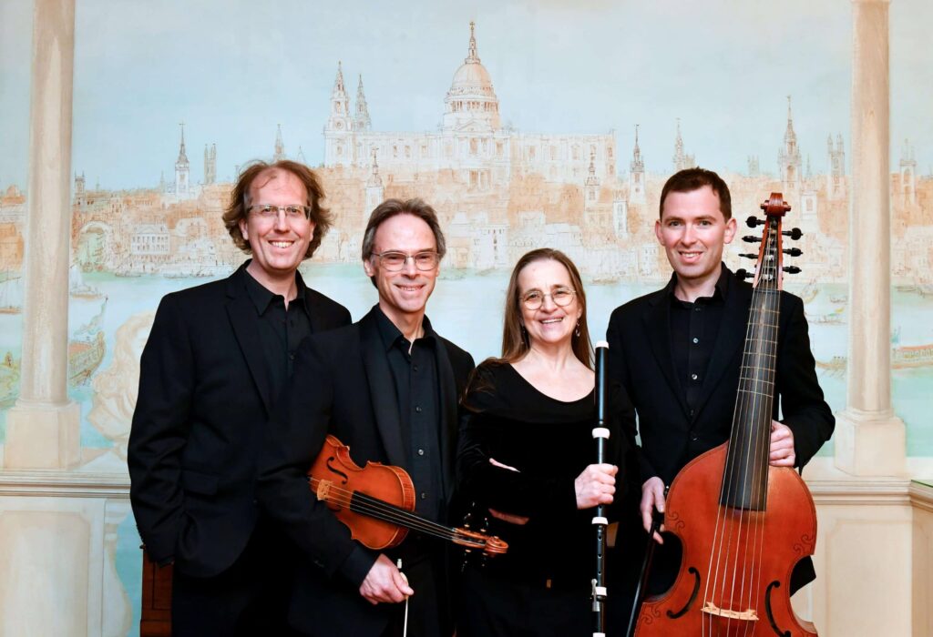 Members of the London Handel Players in a formal group portrait for their baroque performance